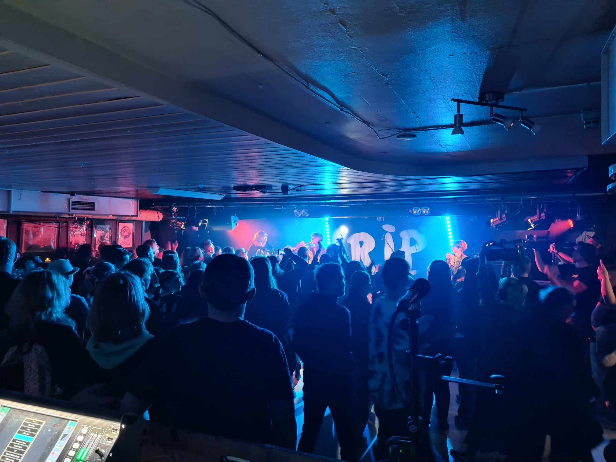 Fullt hus på Rockeklubben i Porsgrunn, med rockeband på scenen. 