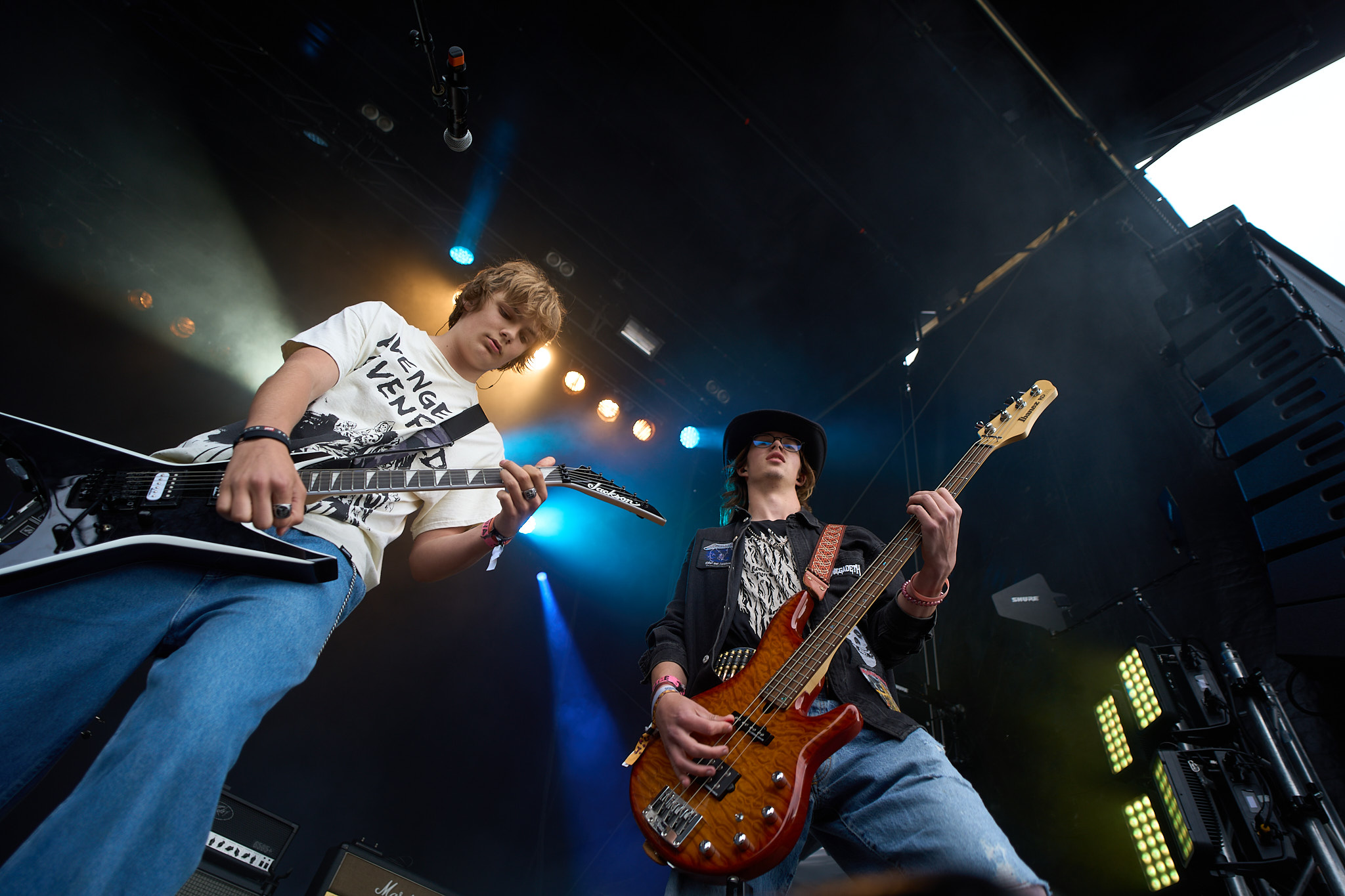 To unge musikere – en gitarist og en bassist, spiller konsentrert på scenen under konsert på Trænafestivalen. 