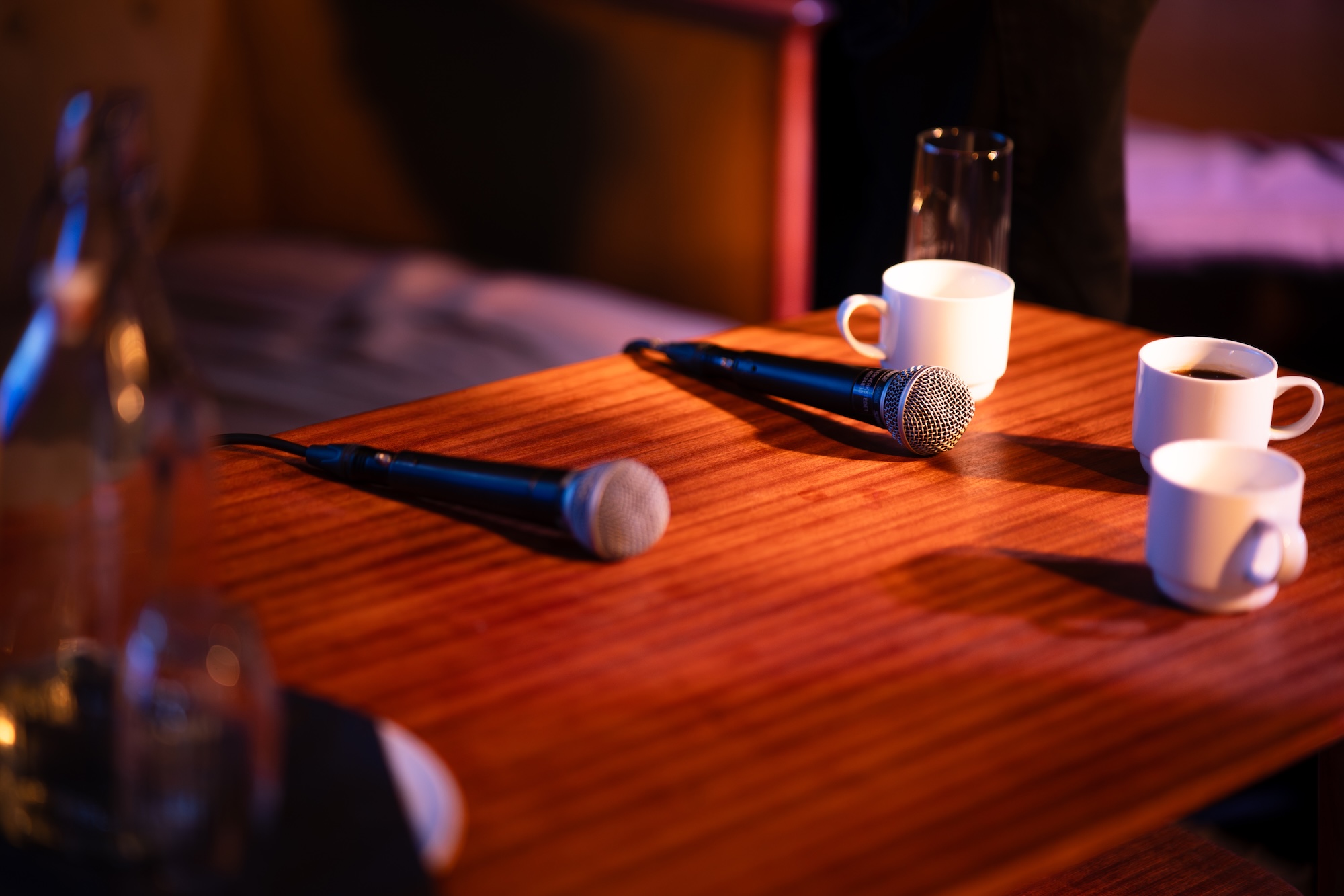 To mikrofoner og tre kaffekopper på et bord.