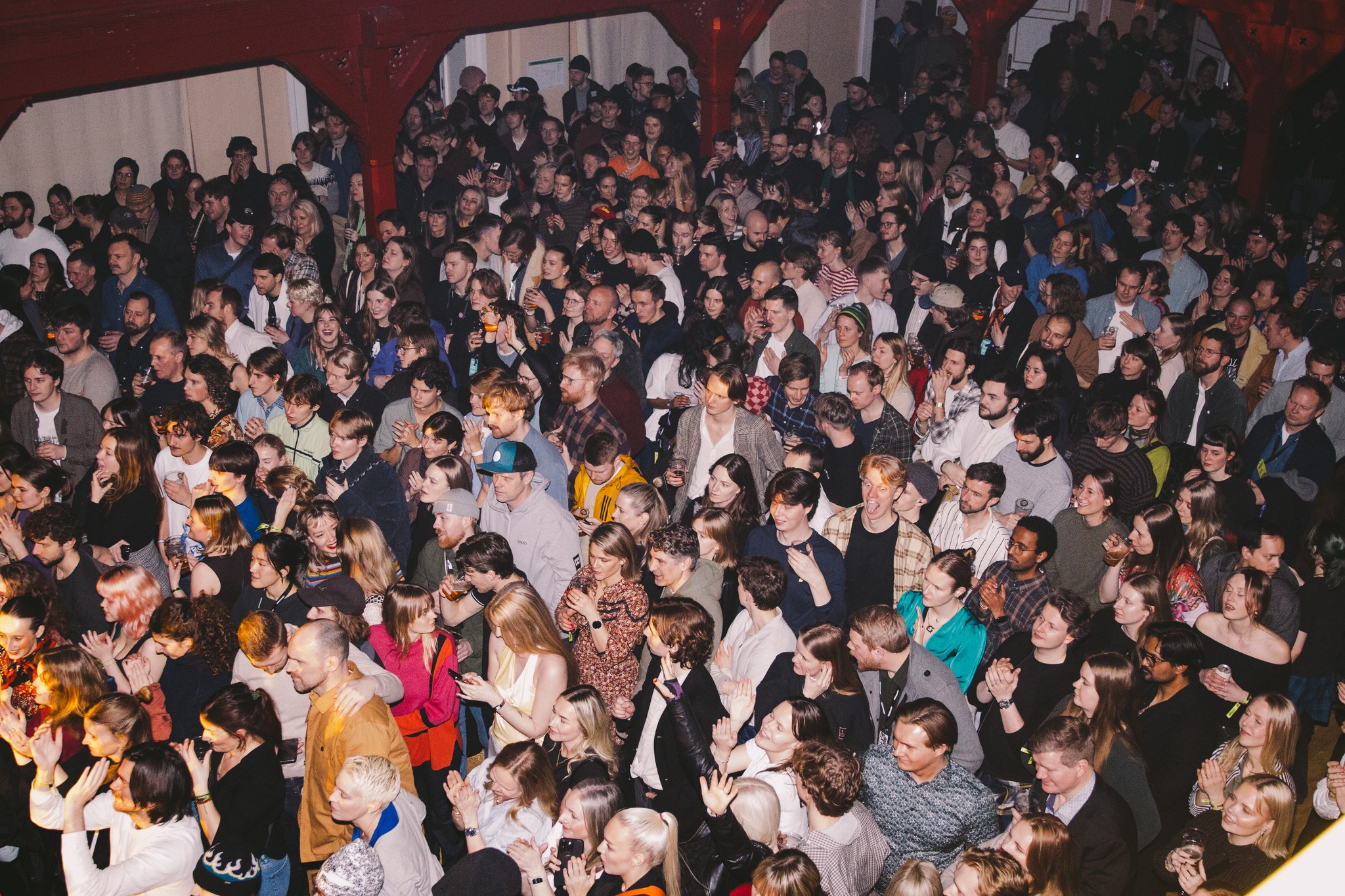 Oversiktsbilde av en stor folkemengde i en konsertsal.